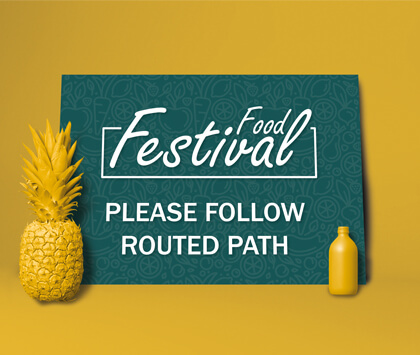 A dark green food festival sign with clear directions on a yellow background.