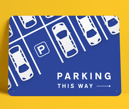A blue directional parking sign on a yellow background.