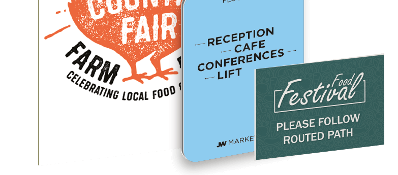 A collection of signage including orange farm fayre sign, light blue directional sign and a dark green food festival directional sign.